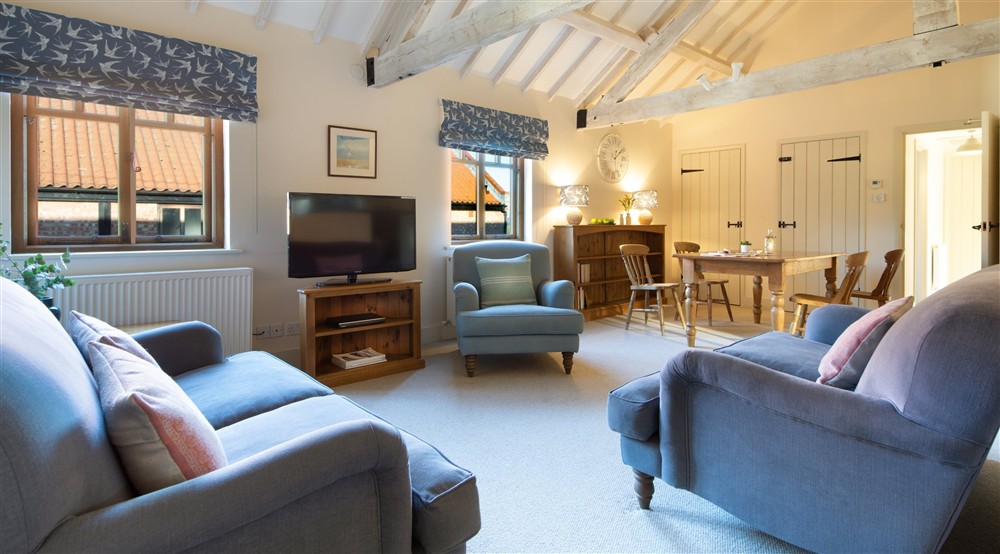 The sitting and dining room at 1 Cart Lodge Barn in Upper Sheringham, Norfolk