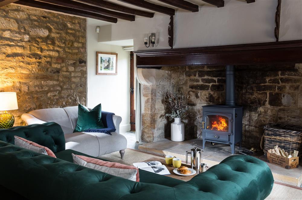 Beautiful sitting room with exposed beams and stonework and a wood burning stove at 1 Chestnut Corner, Stanton, Broadway