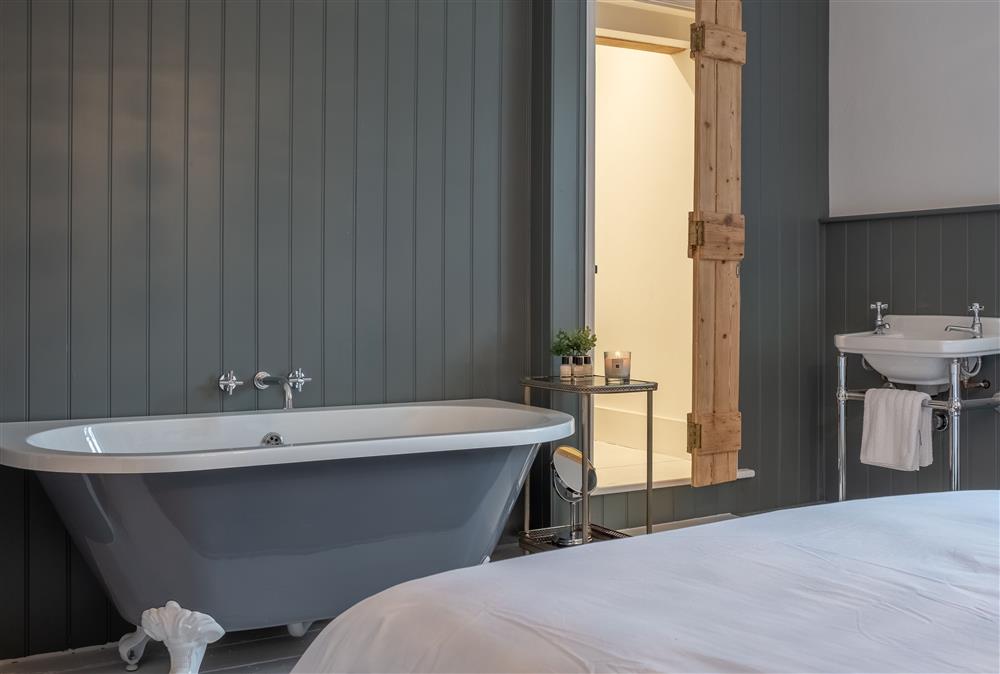 Bedroom one with free-standing bath and wash basin at 1 Church Cottages, Westmeston