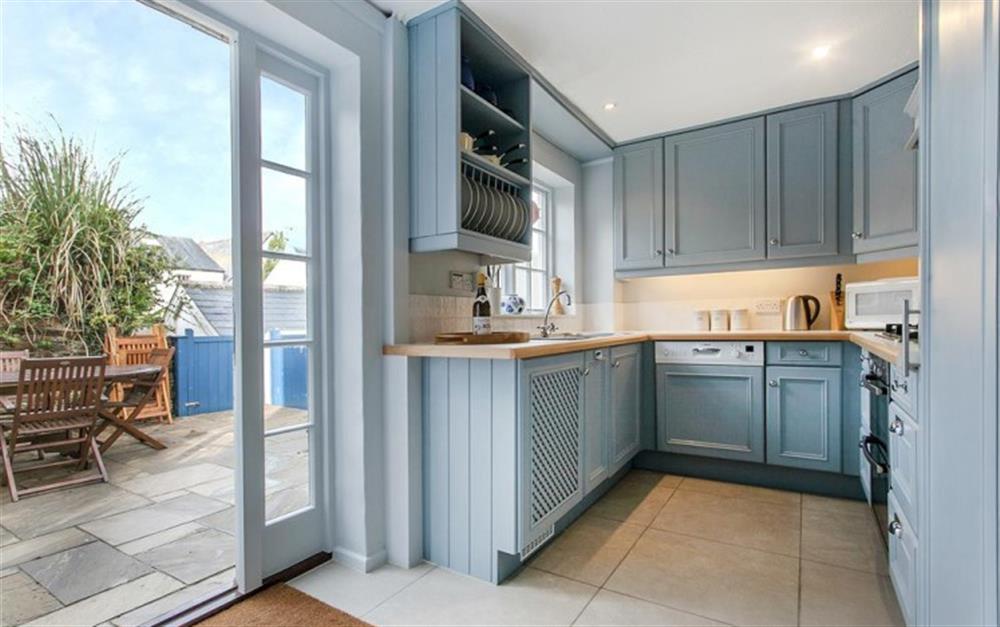 The kitchen with access to patio at 1 Kings Cottages in Salcombe