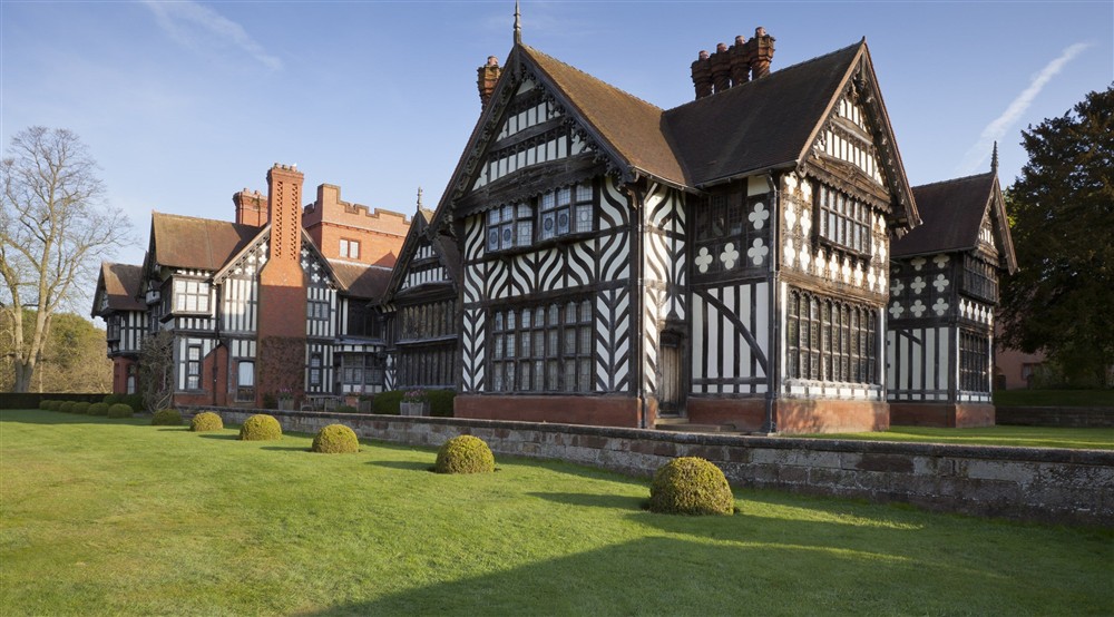 A view of the east wing of Wightwick Manor from across the South Terrace lawn, light by the winter sun.