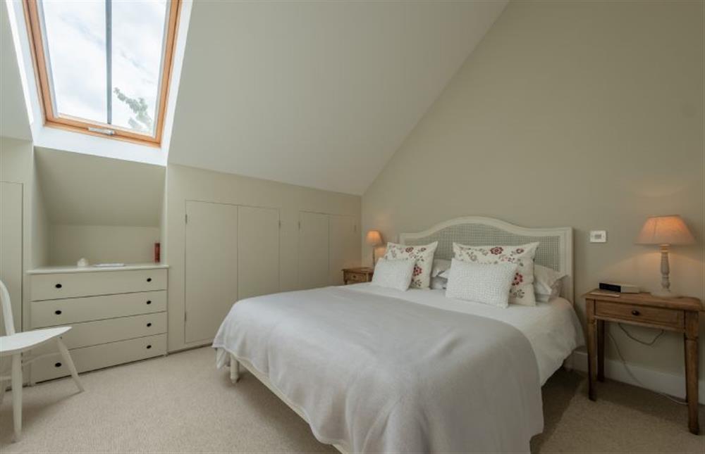 First Floor: Master bedroom with a king-size bed at 1 Railway Cottages, Holt