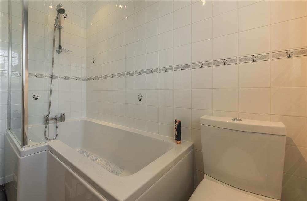 Family bathroom with bath and shower over head at 1 Riverside Cottages, Skipton, North Yorkshire
