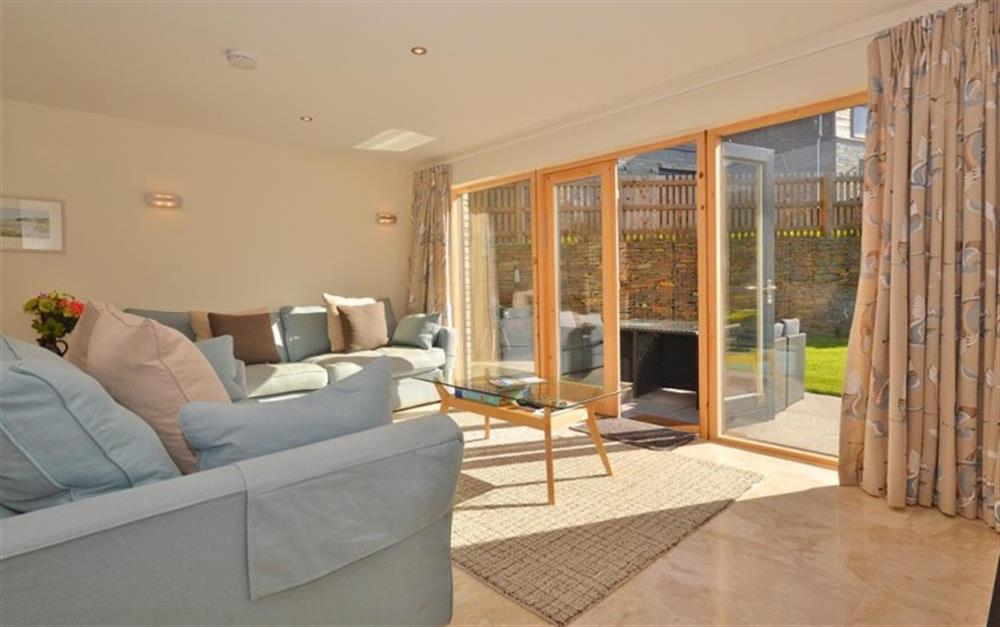 The sunny living room showing the double doors onto the patio at 1 Talland in Talland Bay