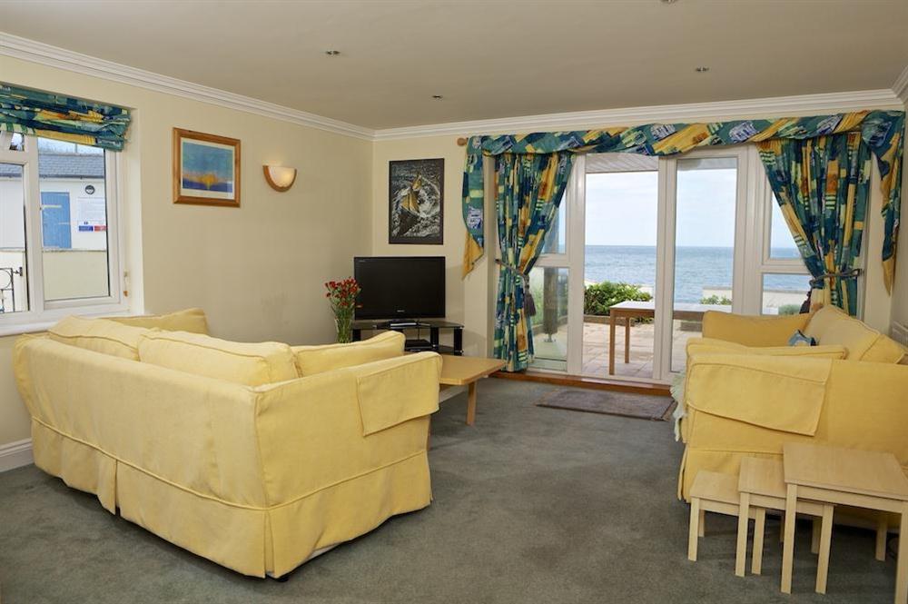 Large comfortable lounge with views out to sea and doors out to patio at 1 Thurlestone Rock Apartments in Thurlestone, Kingsbridge
