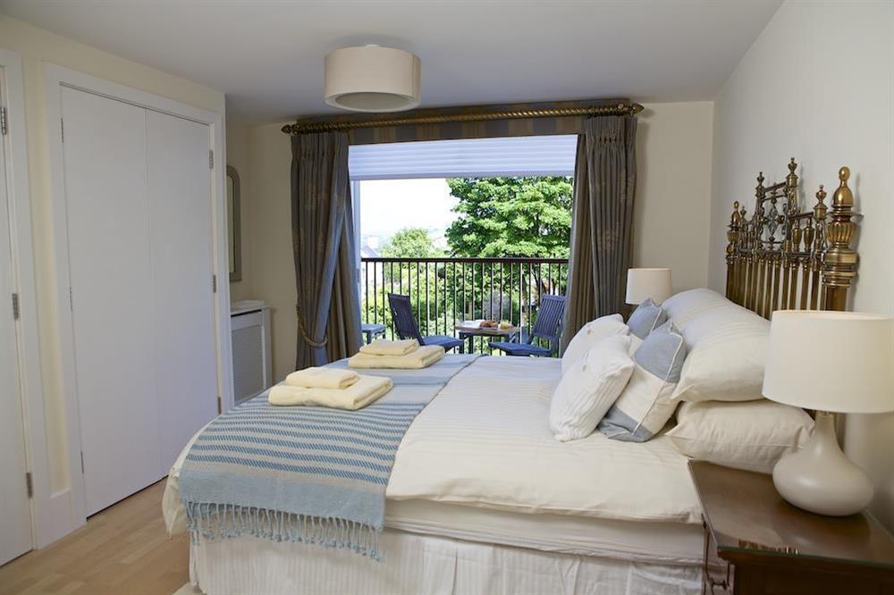 Master bedroom with King-size bed and doors to the balcony at 10 Combehaven in , Salcombe
