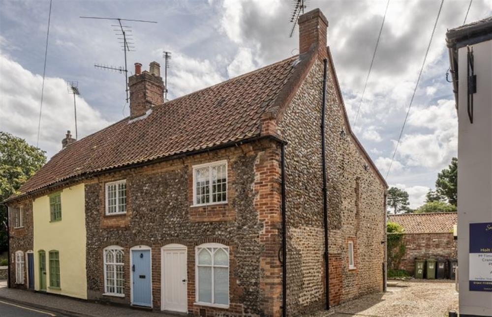 A charming and characterful end of terrace, Grade II listed brick and flint cottage at 12 Station Road, Holt