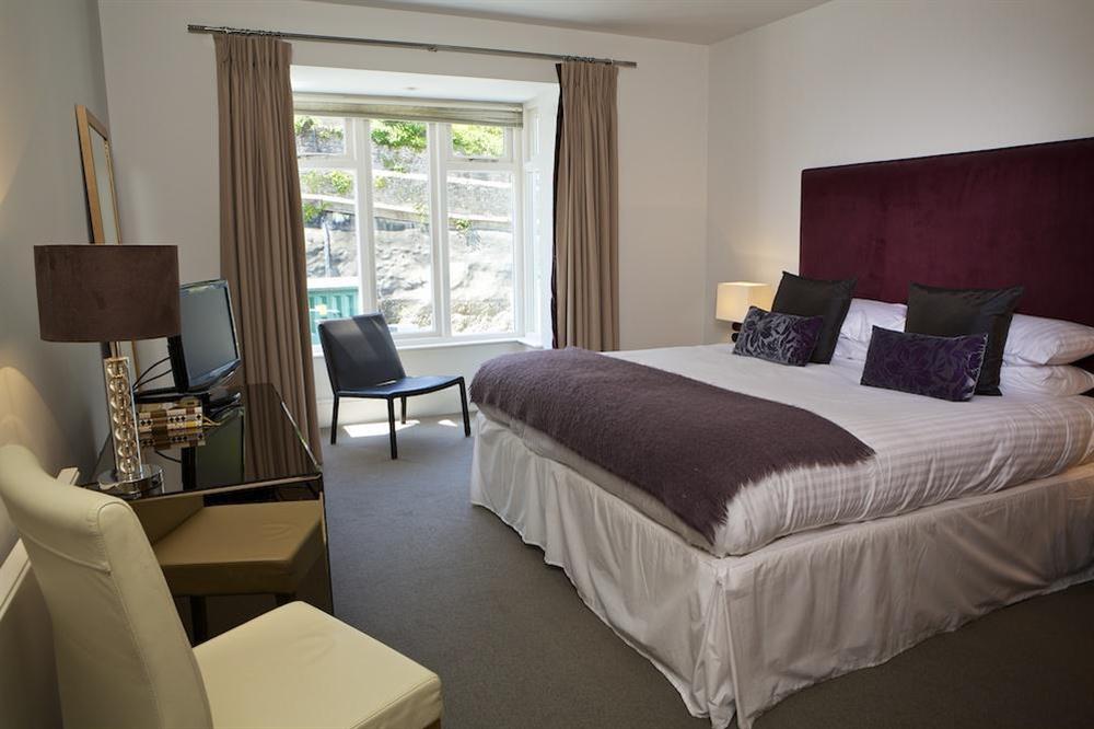 Master bedroom with king size bed and en suite bathroom at 15 Dart Marina in Sandquay Road, Dartmouth