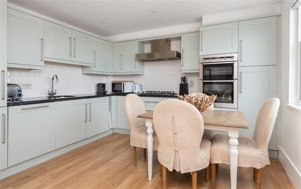 A modern well equipped kitchen with extending dining table at 16 Combehaven in Salcombe