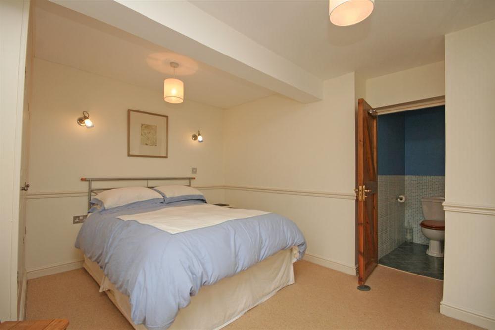 Master bedroom with double bed and en suite bathroom at 2 Armada Apartments in Hope Cove, Nr Kingsbridge