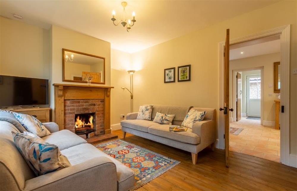 2 Hall Lane Cottages: Cosy sitting room with open fire and wooden flooring at 2 Hall Lane Cottages, Thornham near Hunstanton