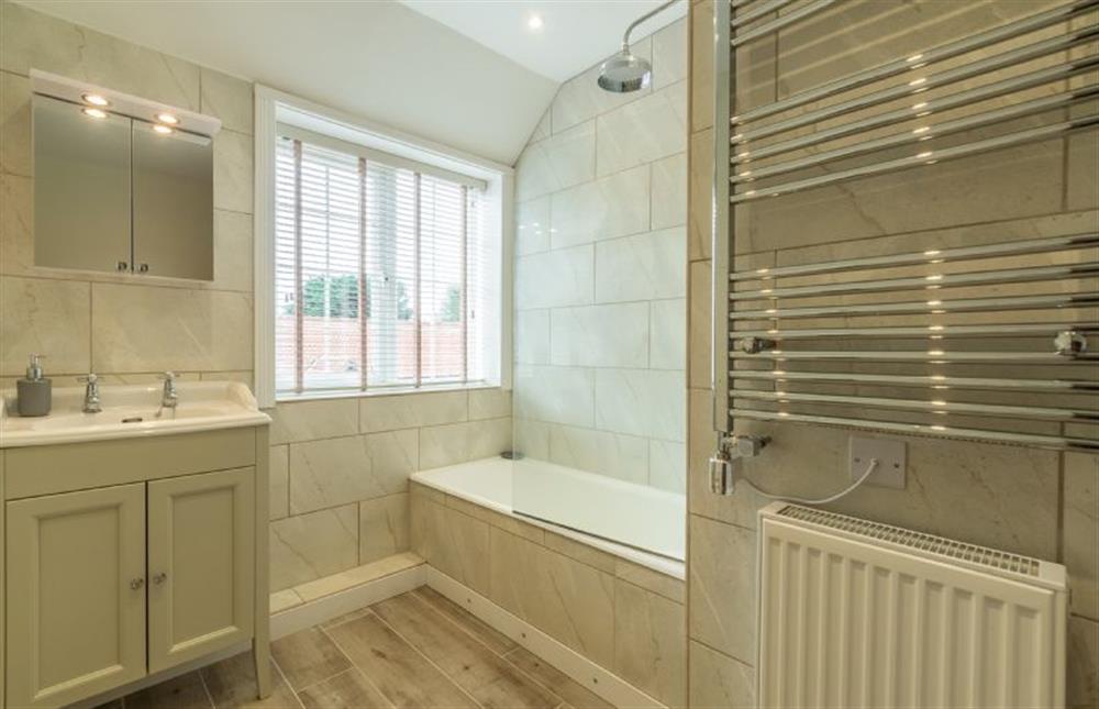 First floor: Family bathroom with shower over bath, WC, hand basin and heated towel rail at 2 Hall Lane Cottages, Thornham near Hunstanton