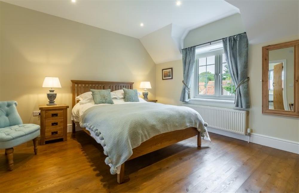 First floor: Master bedroom with king-size bed and Freeview TV at 2 Hall Lane Cottages, Thornham near Hunstanton