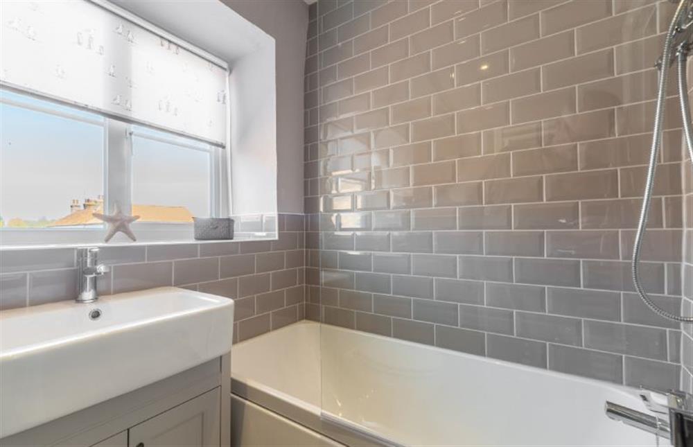 First floor: A fully tiled bathroom with bath and over-head shower at 2 Hammond Square, Weybourne near Holt