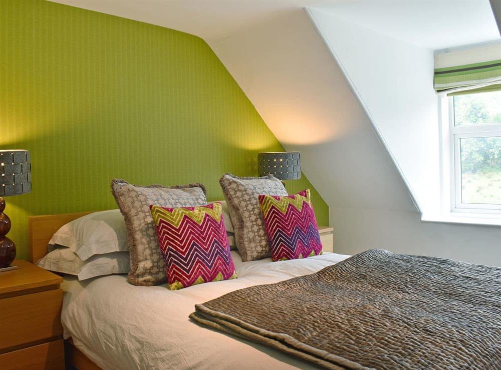 Comfortable bedroom with double bed and single bed at 2 Northbank Cottages in Whiting Bay, Isle of Arran, Scotland