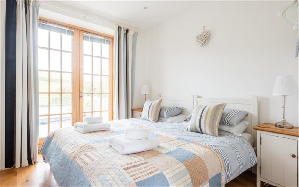 The twin bedroom with doors on to the rear terrace facing the countryside at 2 Prospect House in Hallsands