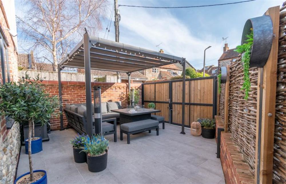 A paved courtyard garden with outdoor seating at 28 Chapel Yard, Wells-next-the-Sea