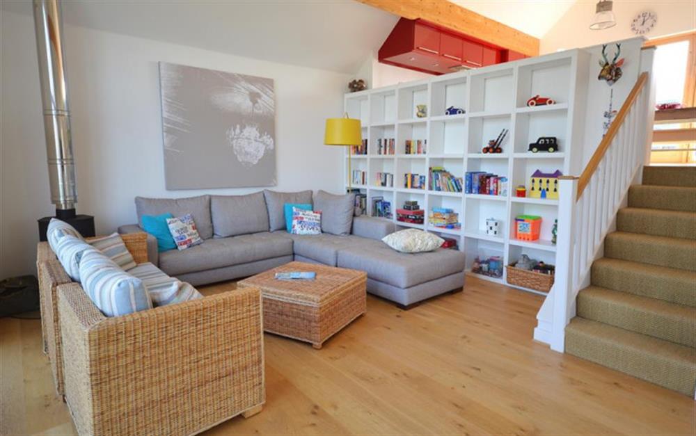 Living room with books and activities shelving at 28 Talland Bay in Looe