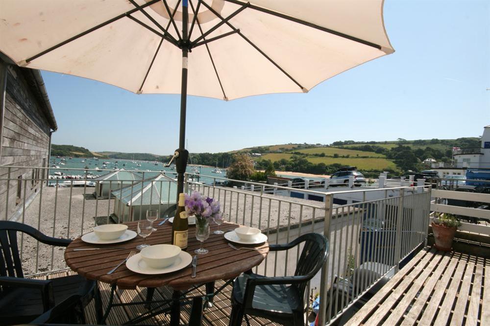 Large decked balcony with table and chairs overlooking the estuary