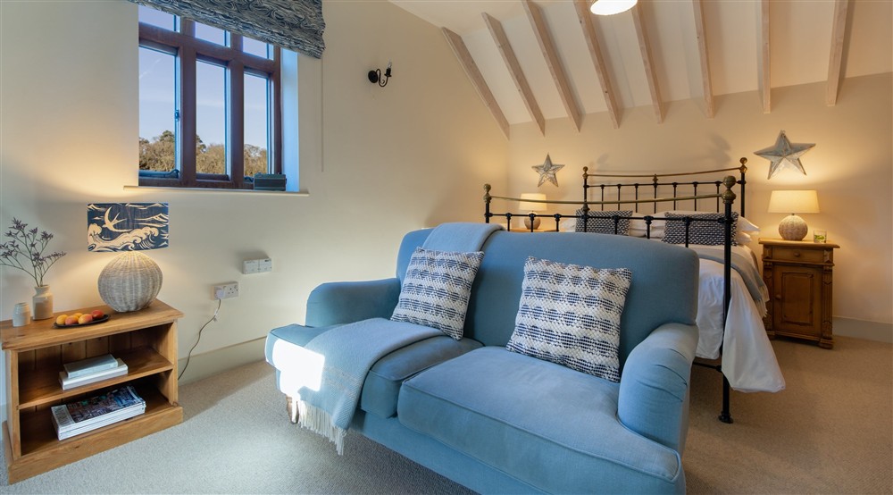 The bedroom and sitting room at 3 Cart Lodge Barn in Upper Sheringham, Norfolk