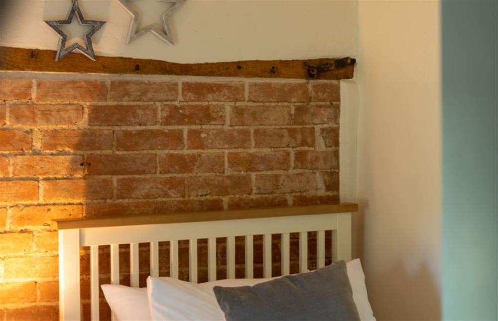 First floor: An exposed brick feature wall in bedroom two at 3 Chapel Cottages, Docking near Kings Lynn