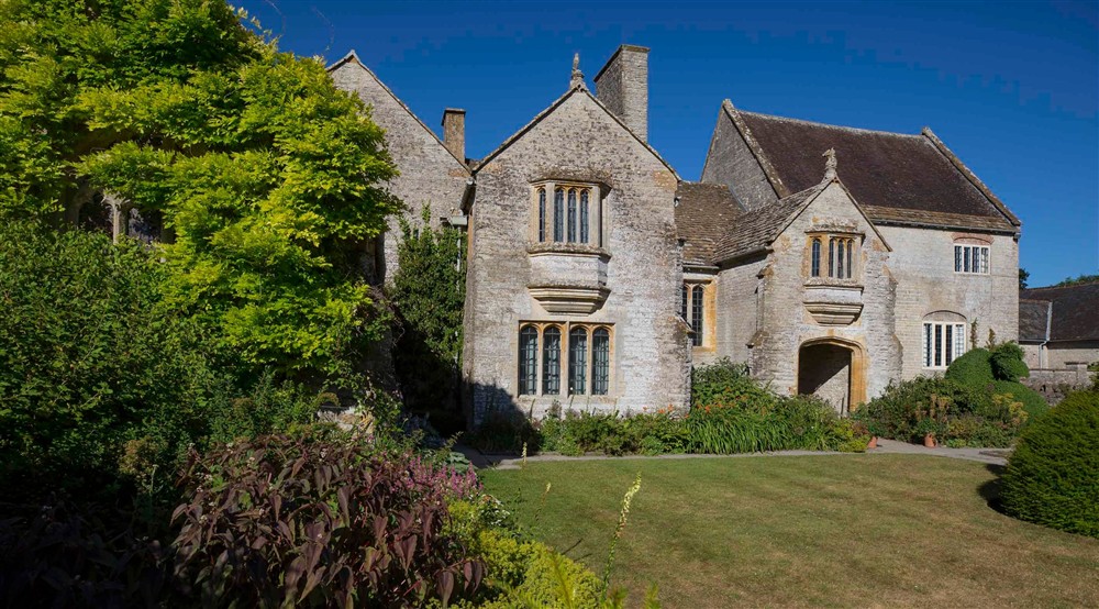 The outside of Lytes Cary in summer with hedges to the left at 3 Lytes Cottage in Somerton, Somerset