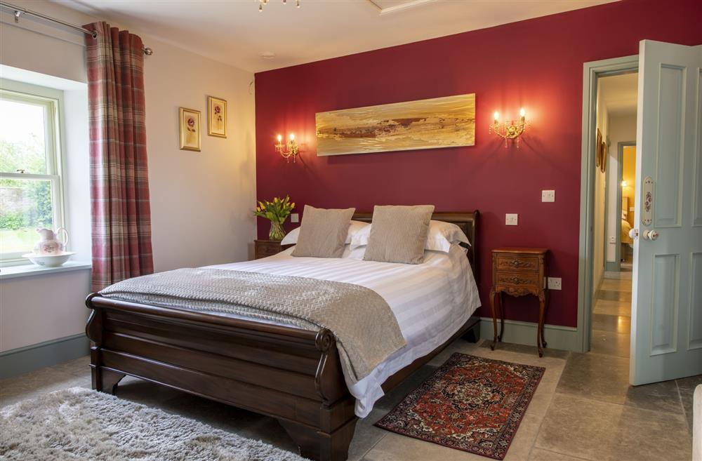 Bedroom one with a 5’ king-size bed and en-suite shower room at 3 Mill Cottages, Richmond