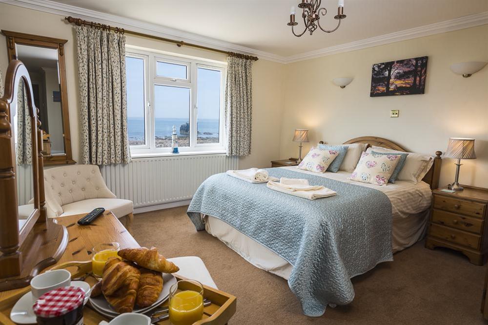 En suite master bedroom with sea views and door to balcony at 3 Thurlestone Rock Apartments in Thurlestone, Kingsbridge