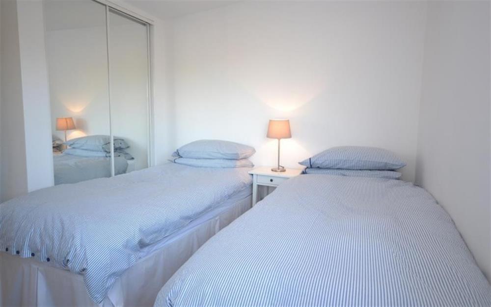 The twin bedroom with access to balcony overlooking water at 3 Waters Edge in Salcombe