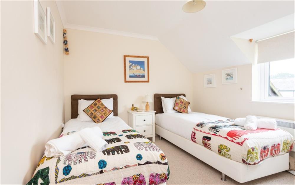 The throws on the twin beds look great against the cream coloured walls at 30 Lower Stables in Maenporth