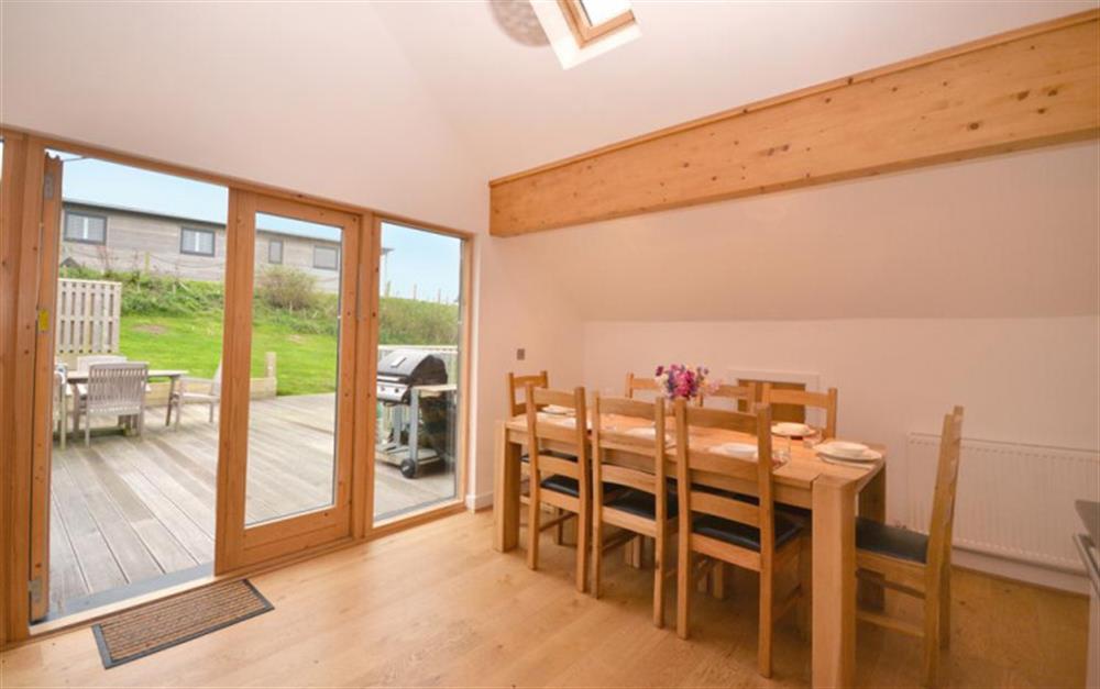 The dining area and view out to the decking outside at 34 Talland in Talland Bay