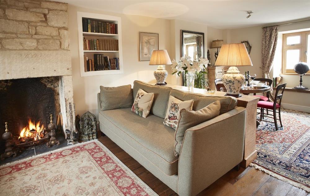 Sitting room with Cotswold stone fireplace and roaring open fire