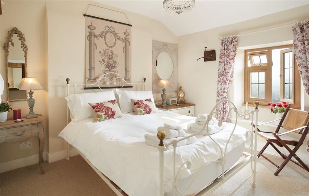 The bedroom with a 5’ king-size bed and rear views of the stunning countryside and deer park at 39 Foxtail Cottage, Blockley