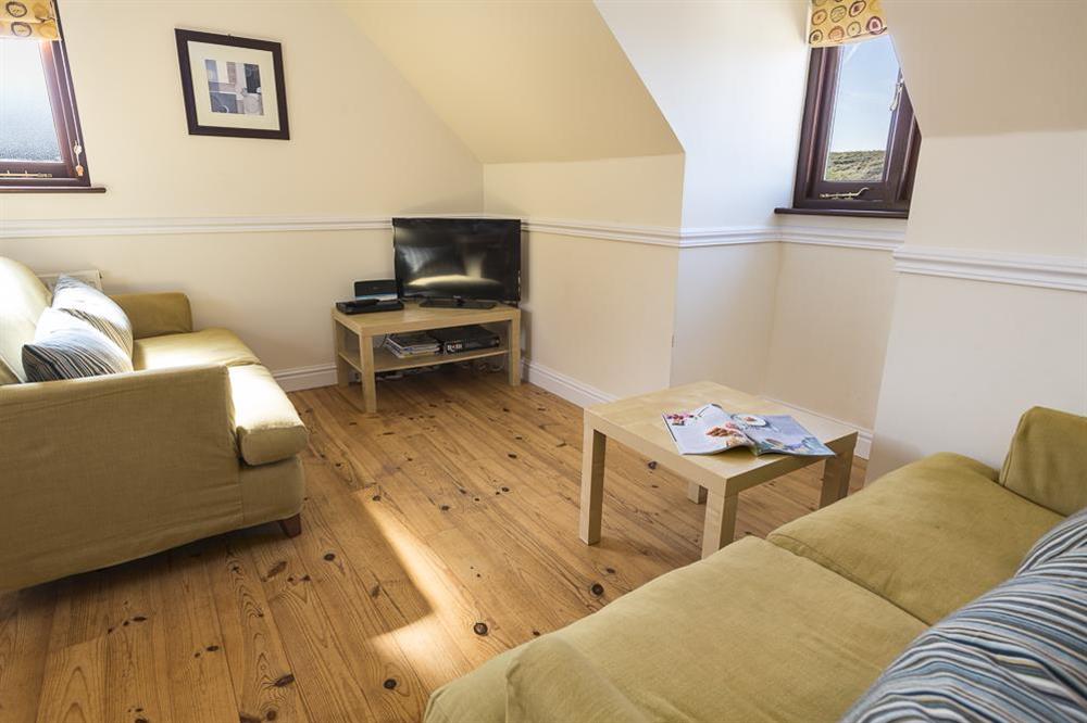 Open plan living area with polished pine flooring at 4 Armada Apartments in Hope Cove, Kingsbridge