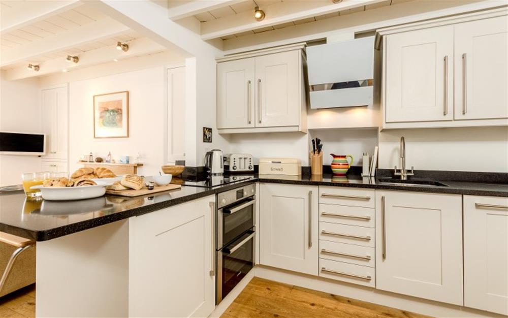 The kitchen is very well equipped and has a useful breakfast bar. at 4 Coastguard Cottage in Helford Passage