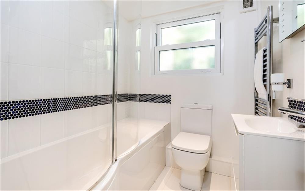 The upstairs family bathroom has a modern suite plus an additional shower over the bath. at 4 Coastguard Cottage in Helford Passage