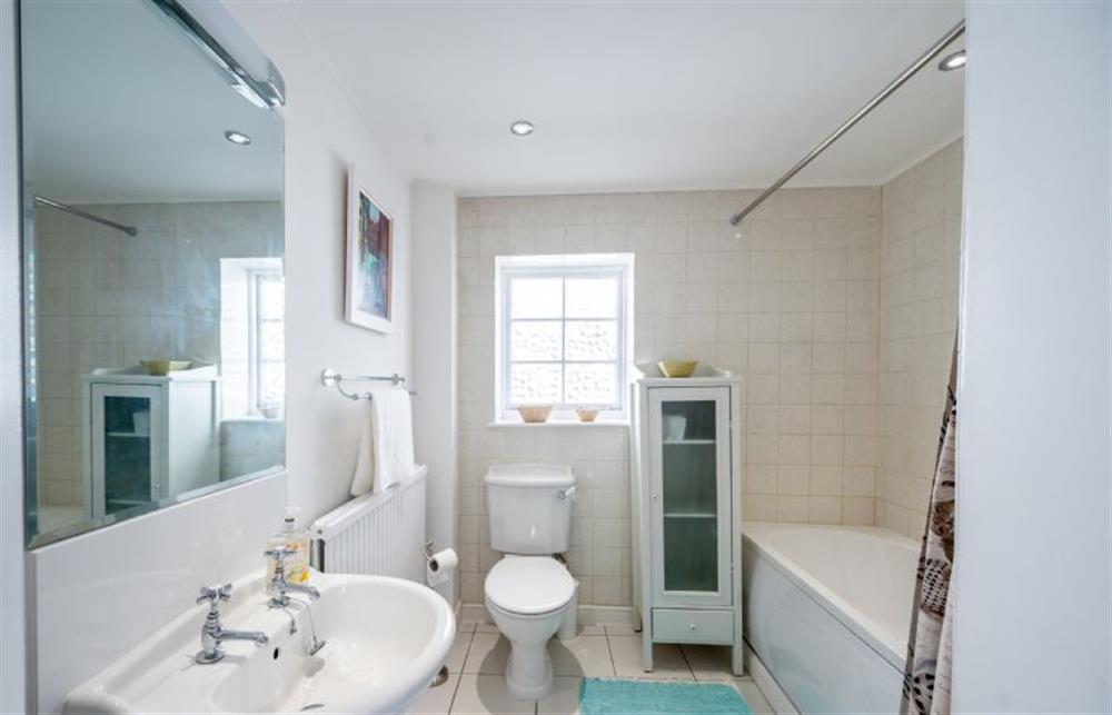 Family bathroom with a bath with a shower over at 4 Cross Street, Holt