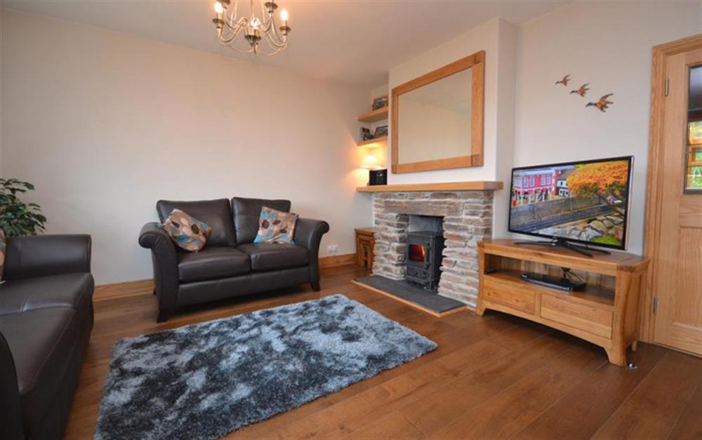 The living room with log burner and views across the Ley  at 4 Florence Cottages in Torcross