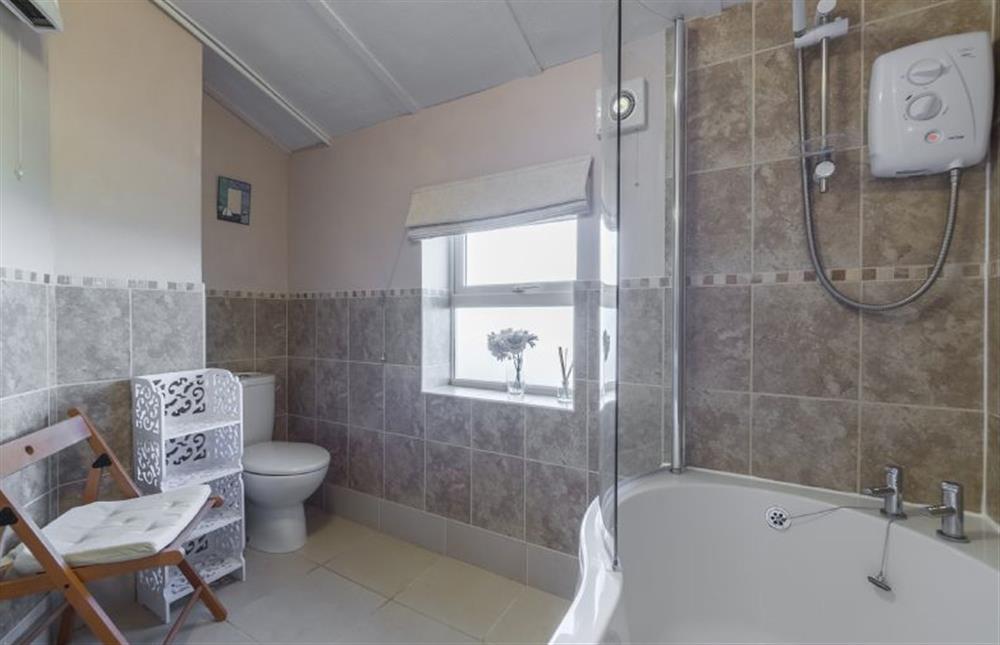 First floor: Family bathroom with shower over bath at 4 Harbour View, Brancaster Staithe near Kings Lynn