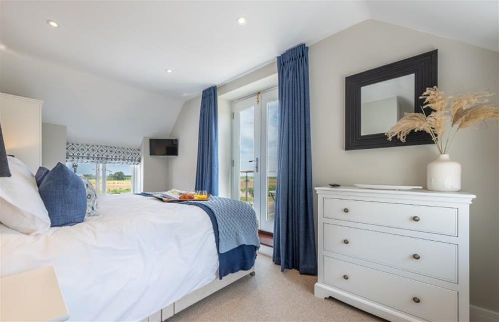 First floor: Master bedroom with balcony at 4 Malthouse Cottages, Thornham near Hunstanton