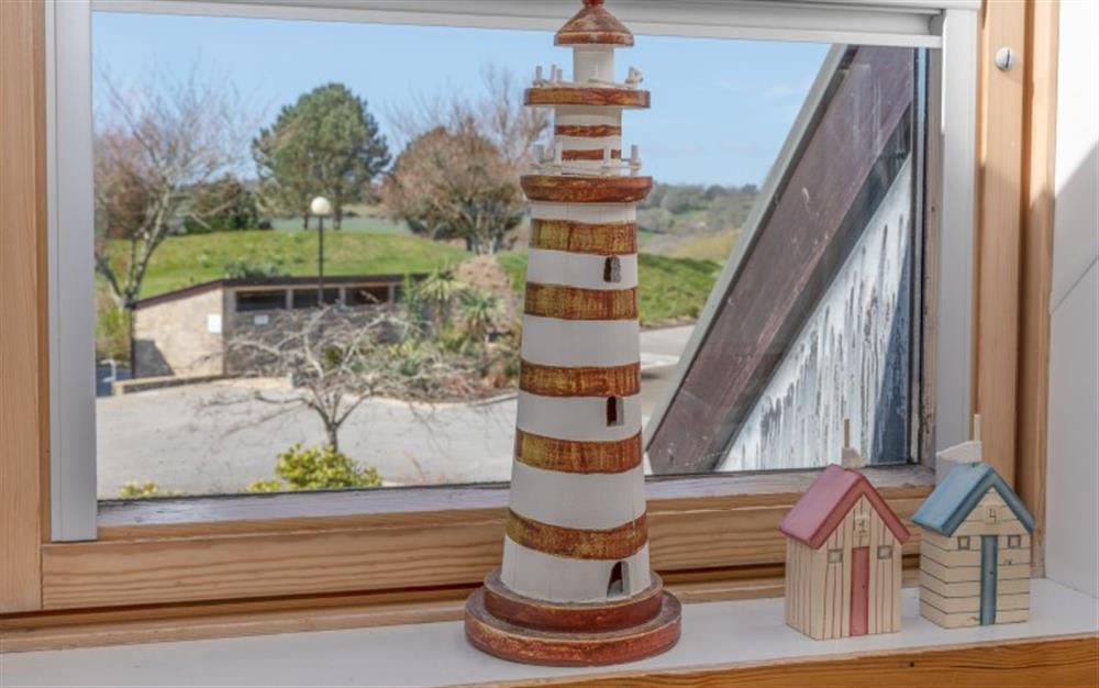 This cute lighthouse and beach huts add to the nautical theme. at 44 Upper Stables in Maenporth
