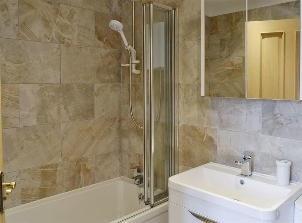 Family bathroom with shower over bath at 5 Ladstock Hall (Deluxe) in Keswick, Cumbria