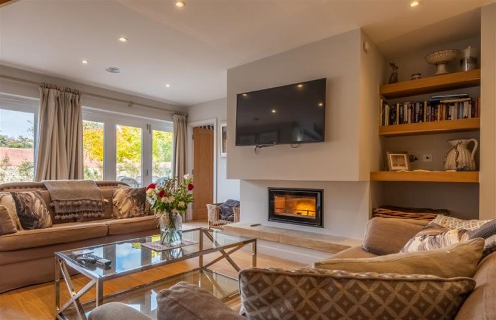 Relax together in front of the feature fireplace  at 5 Manor Farm Barns, Brancaster