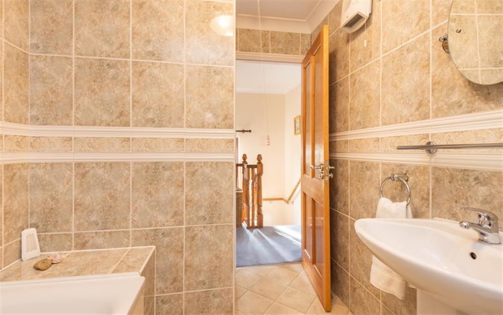 The family bathroom is tiled throughout with large warm coloured tiles at 55 Upper Maen Cottage in Maenporth