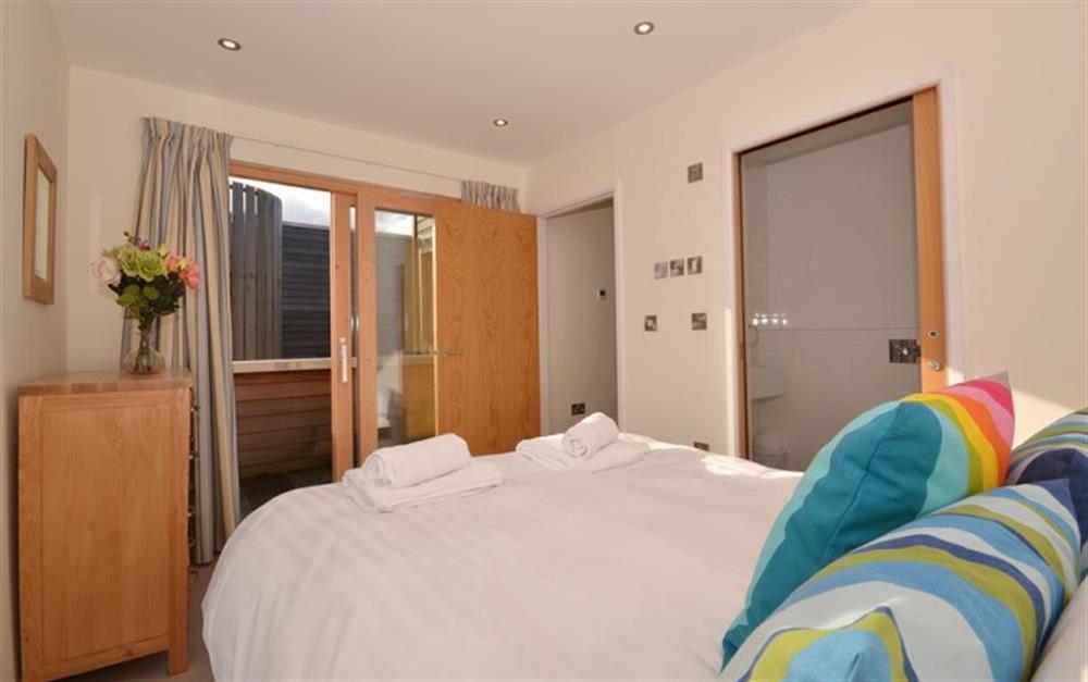Another view of the master bedroom, showing the balcony and en suite at 6 Talland in Talland Bay