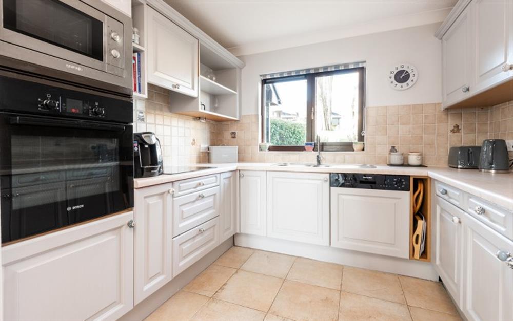 Decorated in a cool shade of grey, the kitchen has everything you need including a Tassimo coffee machine. The kitchen has full sized integrated appliances. at 62 Lower Maen Cottage in Maenporth