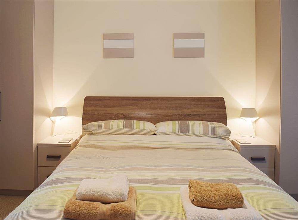 The double bedroom boasts a leather king size bed at 7 Ladstock Hall (deluxe) in Keswick, Cumbria