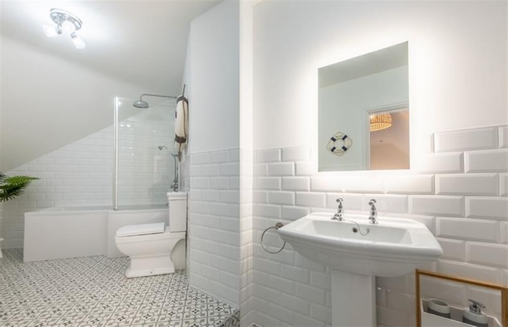 Second floor: Bathroom with a bath with shower over, WC and wash basin at 7 Montague Road, Sheringham