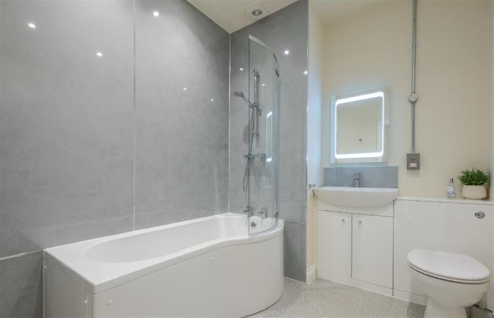 First floor: Bathroom with bath and overhead shower at 7 Swan Court, Fakenham