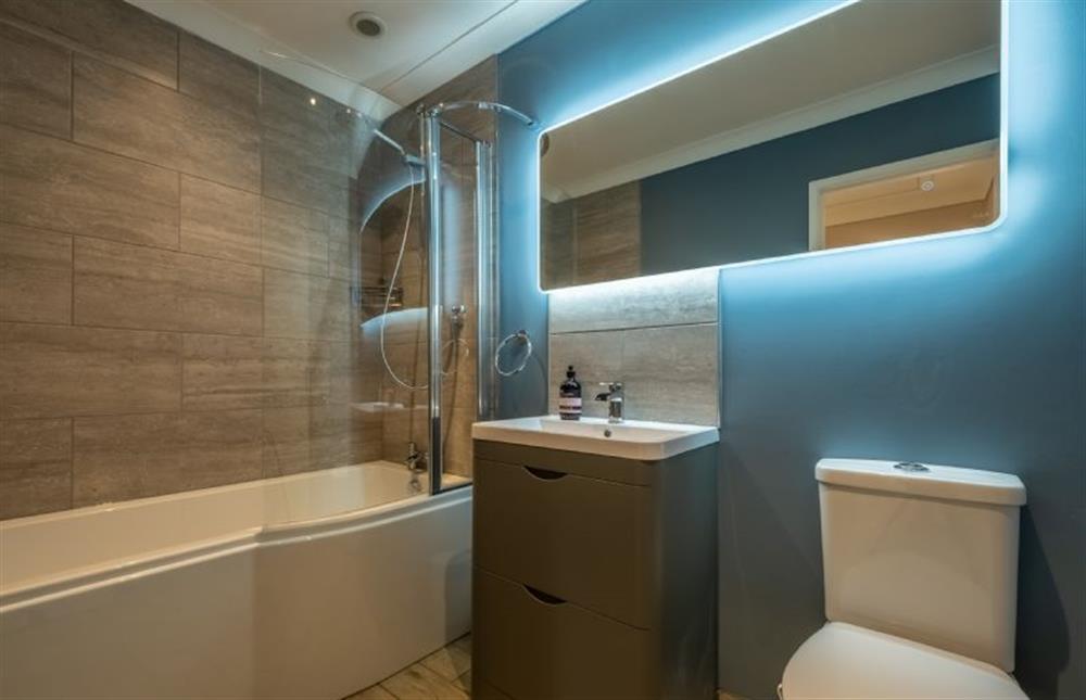 Family bathroom with a bath and shower over, heated towel rail, wash basin and WC at 8 Town Close, Holt